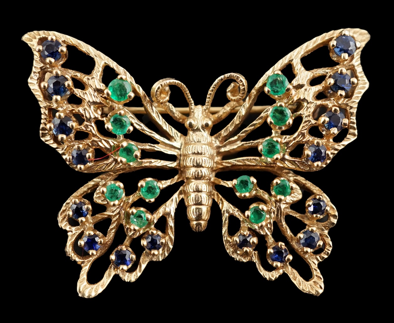 A modern pierced 14ct gold, emerald and sapphire cluster set butterfly brooch